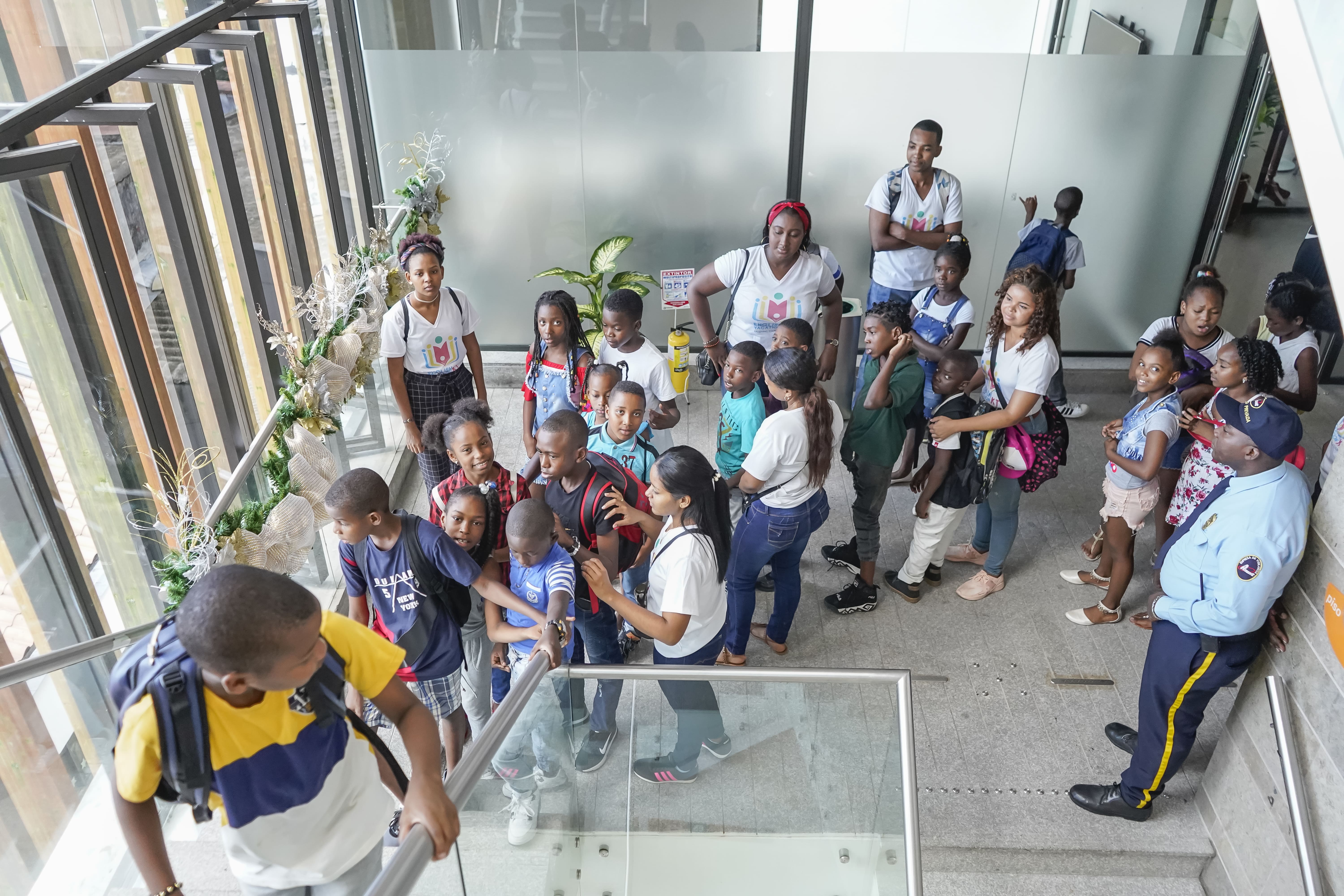 la imagen puede contener a un grupo de personas entre jovenes,niños y adultos en fila para subir unas escaleras.