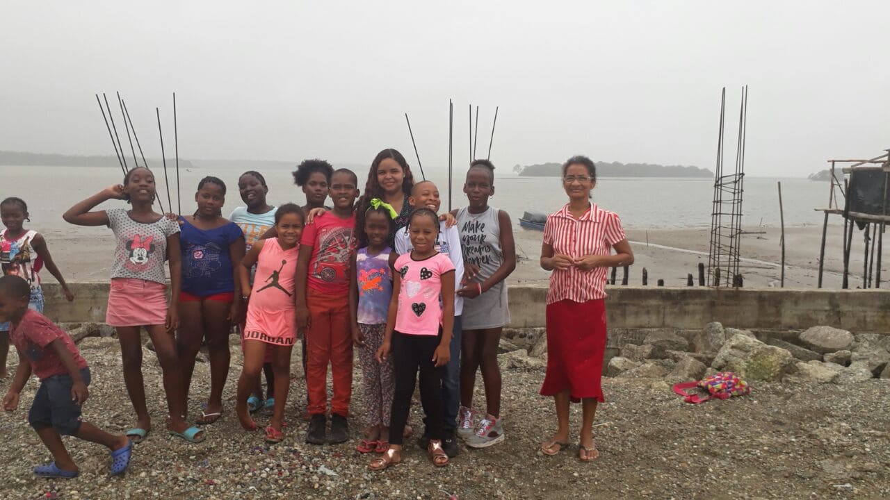 la imagen puede contener a un grupo de niños de pie,posando sonrientes y alegres